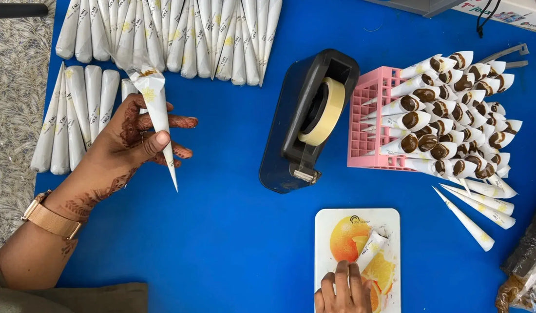 Production de Henné Réunionnaise 974 avec Tiitoune art, tubes remplis de henné sur une table.
